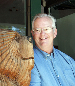 Photo of John Martinelli with a carved bear statue at Lake Tahoe